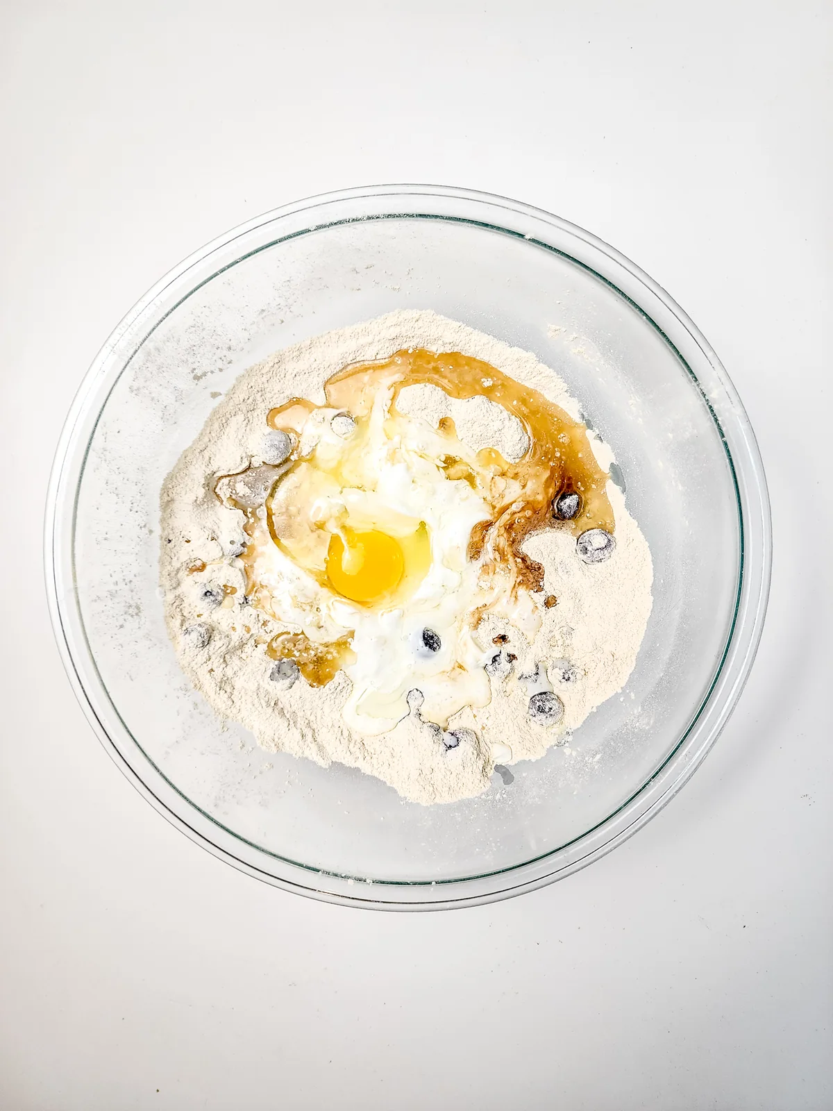 Muffin ingredients combined in a glass bowl before they are mixed together.