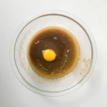 Egg added to the butter and brown sugar mixture for blondie batter.
