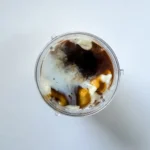 Vanilla ice cream, milk, caramel sauce, and butterscotch sauce in a blender before blending.