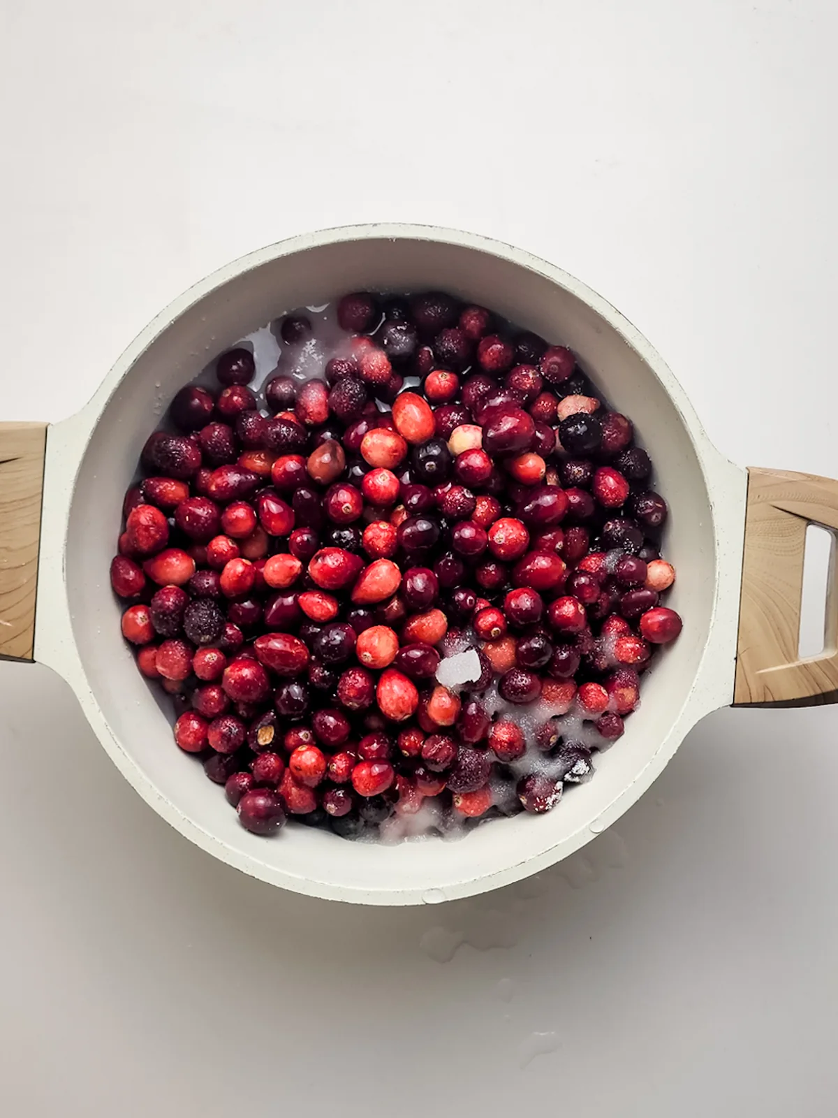 Fresh cranberries in water in a large pot before cooking.