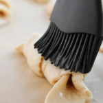 Easy Crescent Roll Churros With Dulce de Leche Brushing melted butter onto an unbaked crescent roll