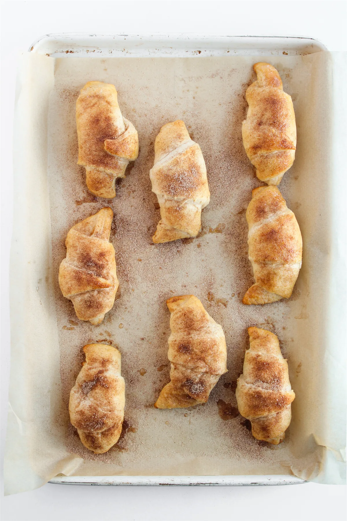 Easy Crescent Roll Churros With Dulce de Leche Baked crescent roll churros coated in cinnamon sugar on a baking sheet
