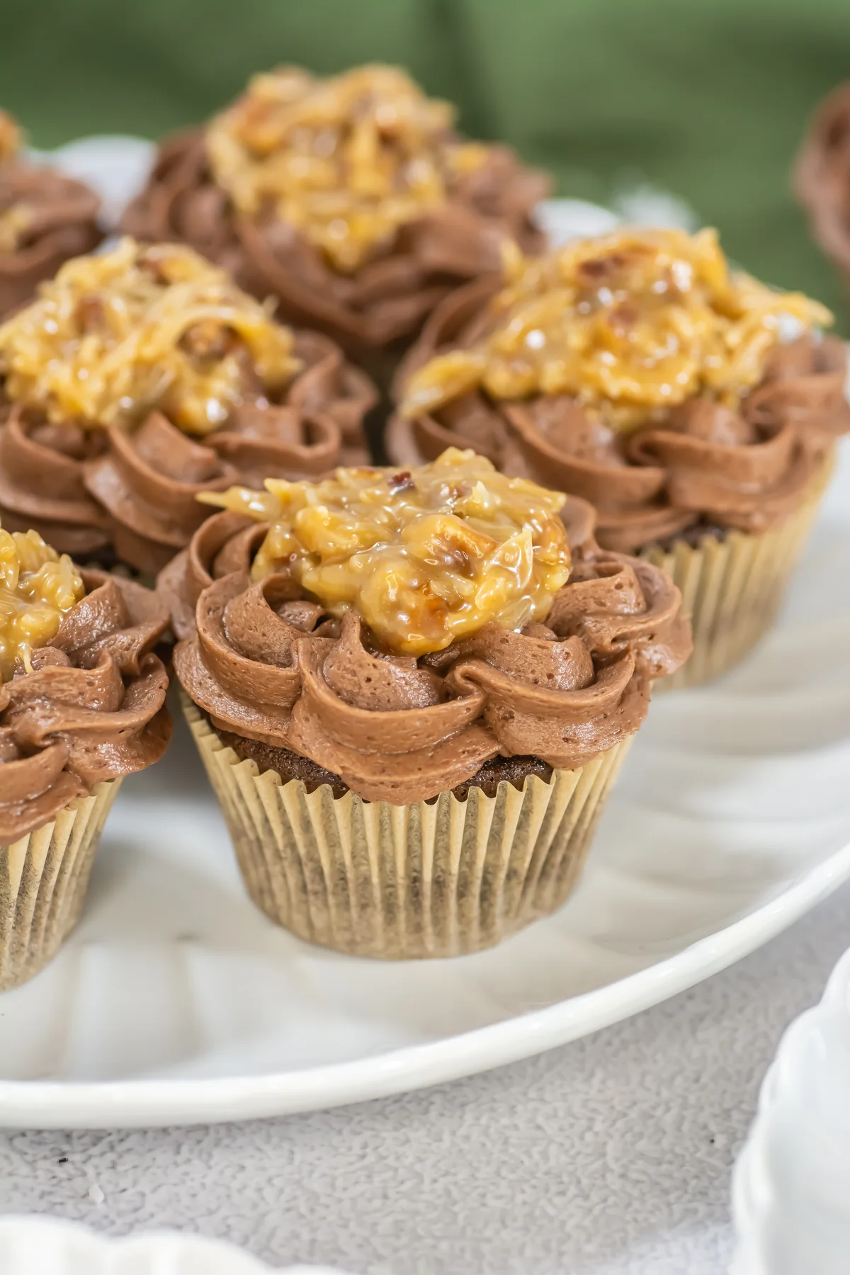 Closeup of German chocolate cupcakes with chocolate frosting and coconut-pecan topping.