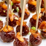 Rows of Hawaiian meatballs with pineapple chunks on bamboo picks