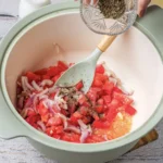 Tomato Bisque Soup With Fresh Tomatoes (Small Batch for Two) Sprinkling dried basil over the tomatoes and onion in the pot